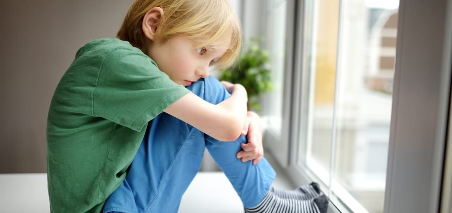 sad-little-boy-is-sitting-near-window-and-watching-2022-11-11-19-12-37-utc